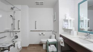 A modern bathroom with a shower, toilet, and sink.