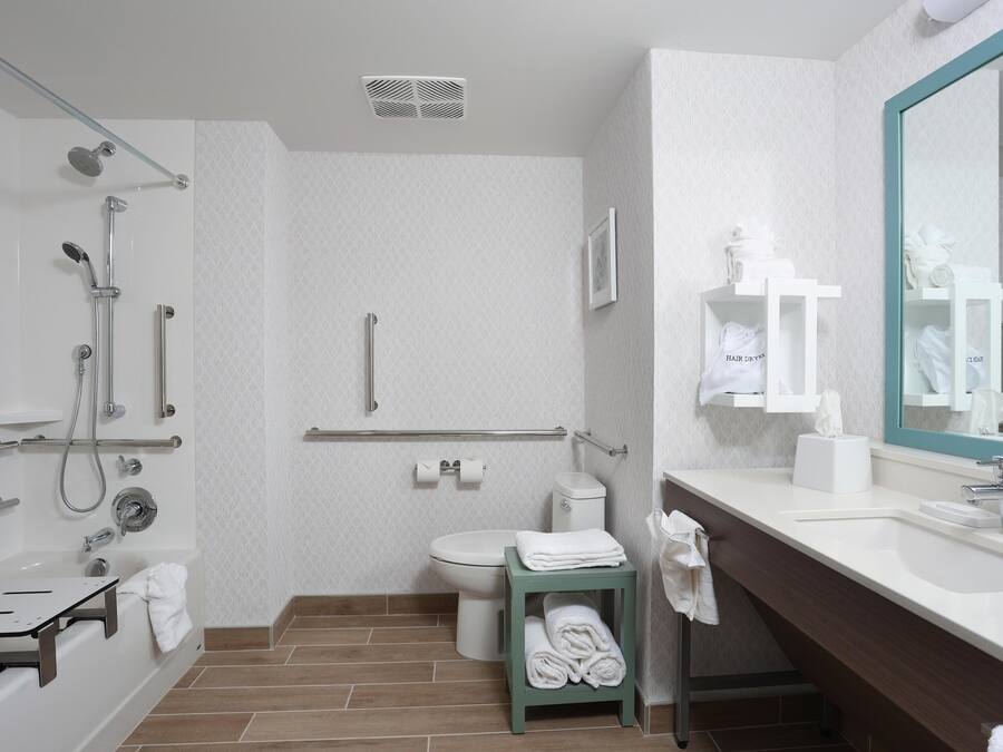 A modern bathroom with a shower, toilet, and sink.