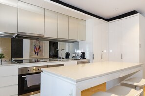 Enjoy cooking in this well-equipped kitchen with a large island, oven, and modern sink.