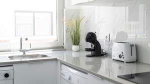 Une cuisine moderne équipée d’un lave-vaisselle, d’un grille-pain et d’une plante en pot.