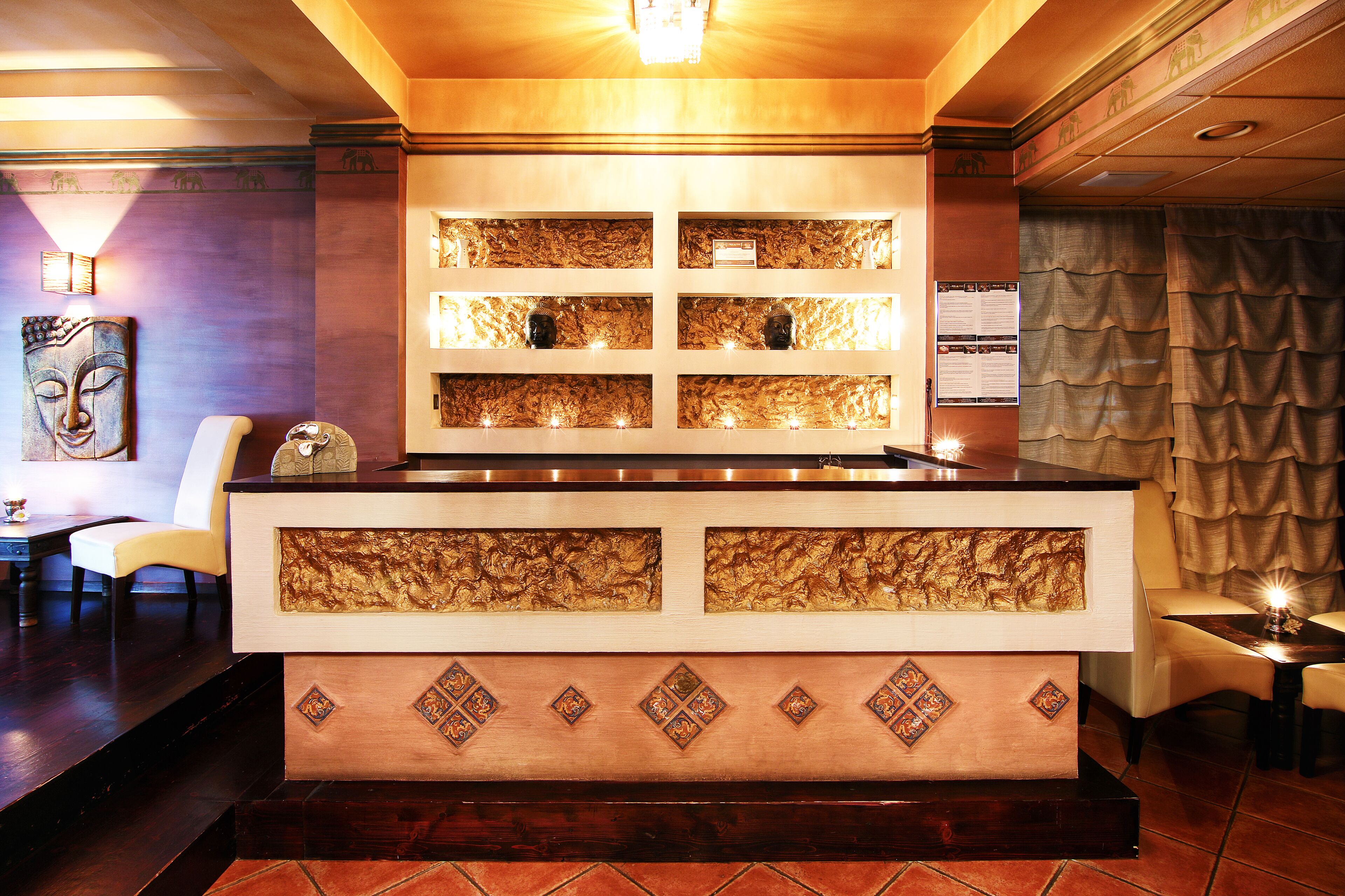 A reception area with a counter, decorative panels, and seating.