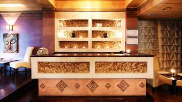 A reception area with a counter, decorative panels, and seating.