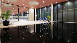Um espaço interior moderno com piso refletivo, cadeiras azuis e um vaso de planta.