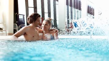 Relax by the pool with a clear view through large windows and comfortable seating.
