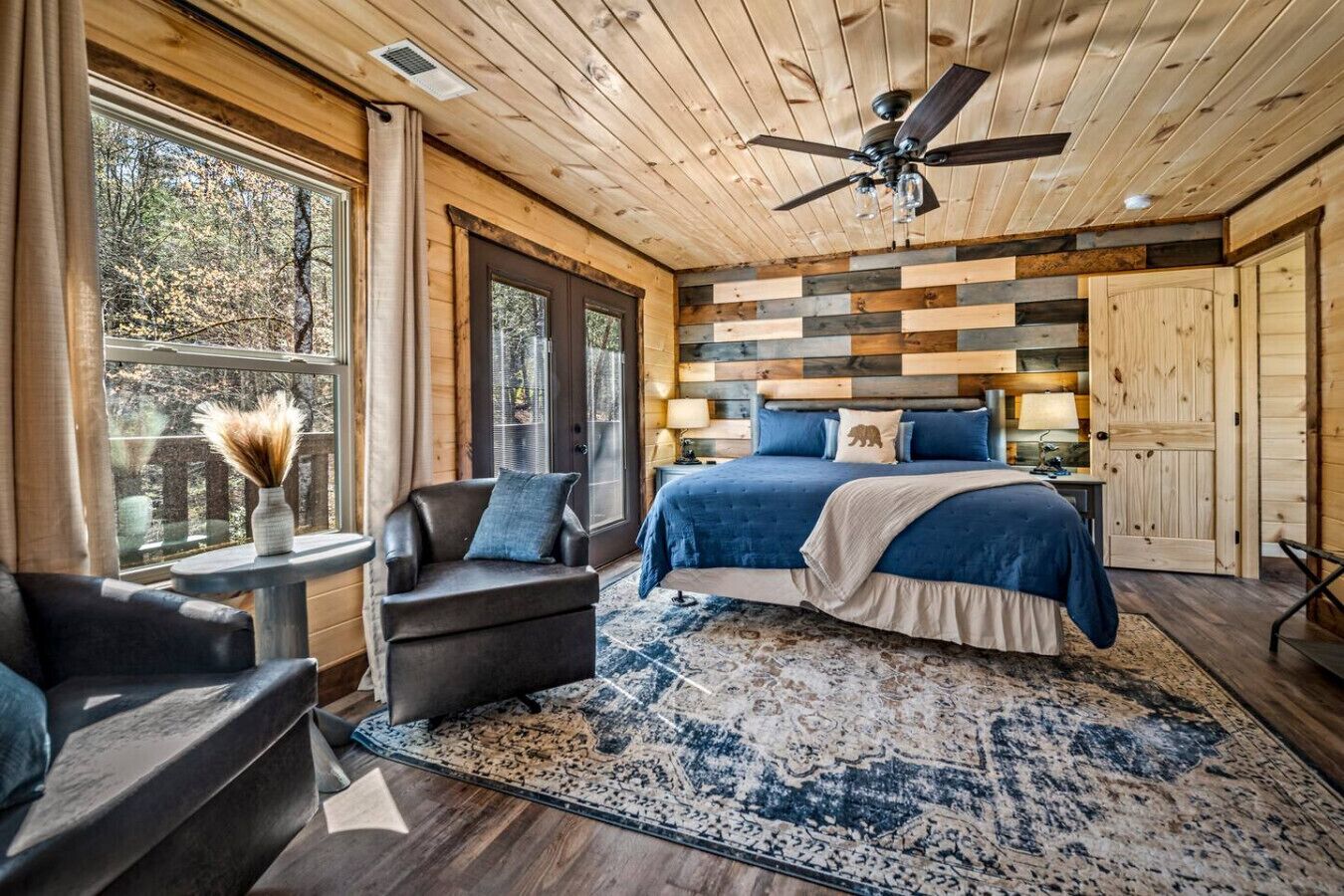 A bedroom with a bed, a chair, a table, and a window.