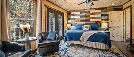 A bedroom with a bed, a chair, a table, and a window.