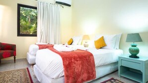 A hotel room with a bed, a nightstand, a lamp, a chair, and a window with curtains. - Serene haven on the outskirts of Marrakech w/ pool (Marrakech)