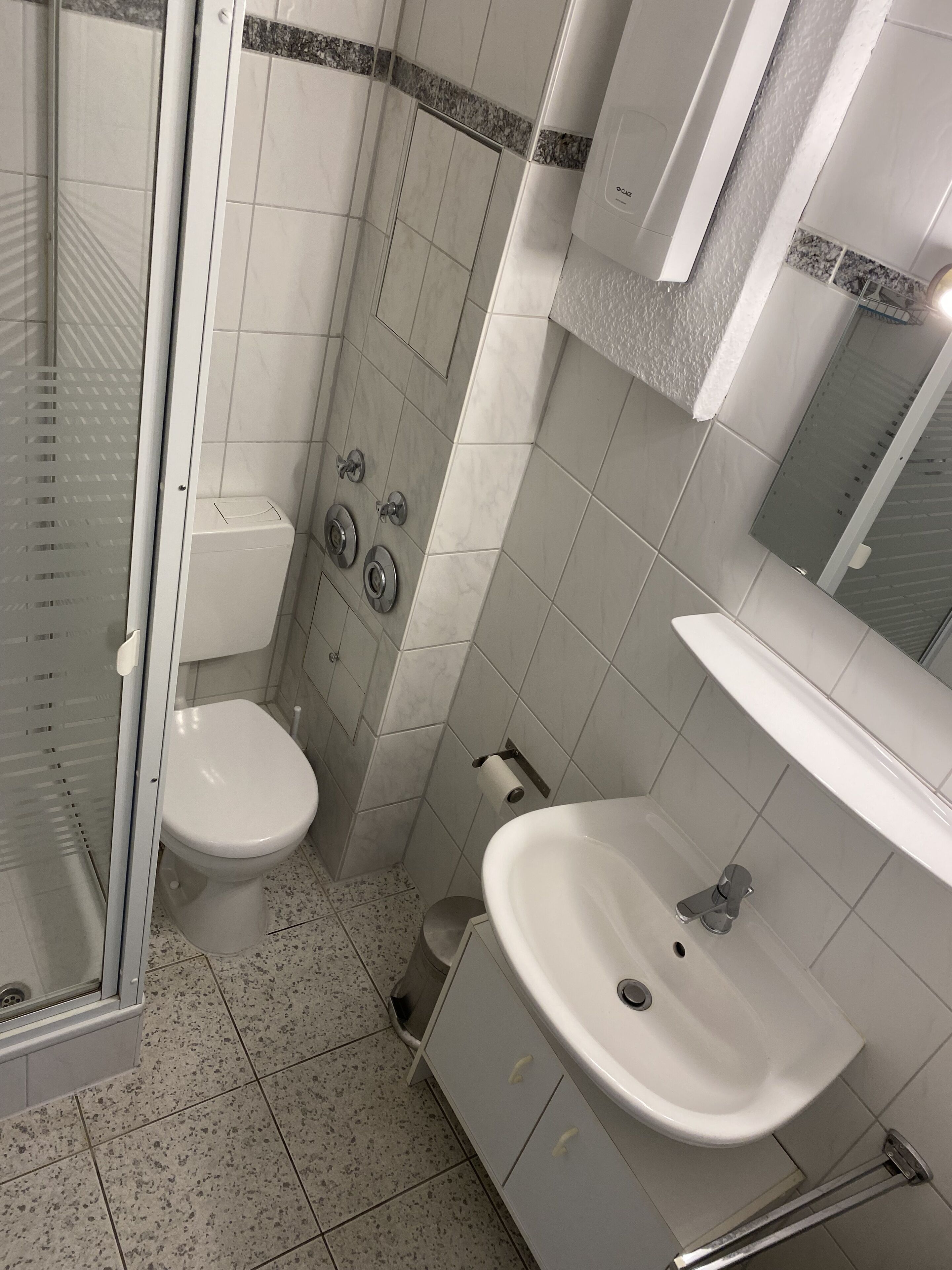 A bathroom with a toilet, a sink, and a shower.