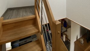Una escalera de madera con barandilla metálica que conduce a una plataforma.