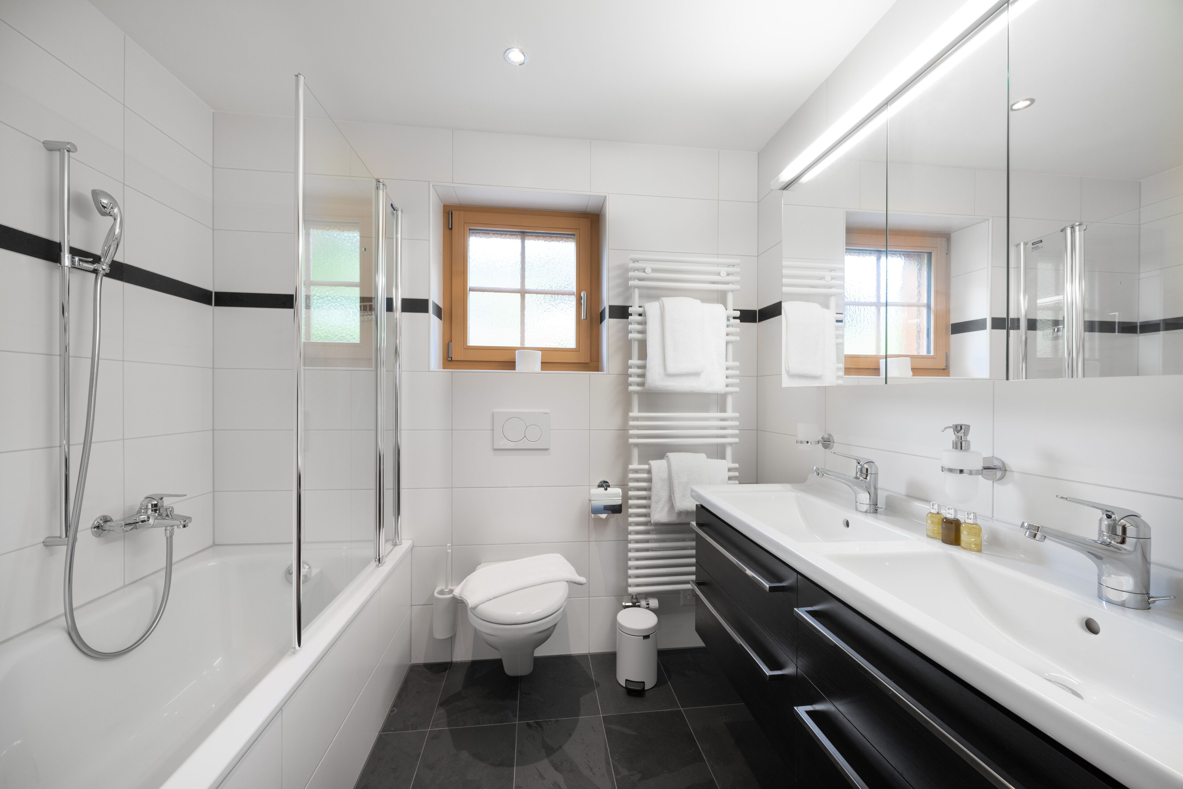 A modern bathroom with a bathtub, toilet, and sink.