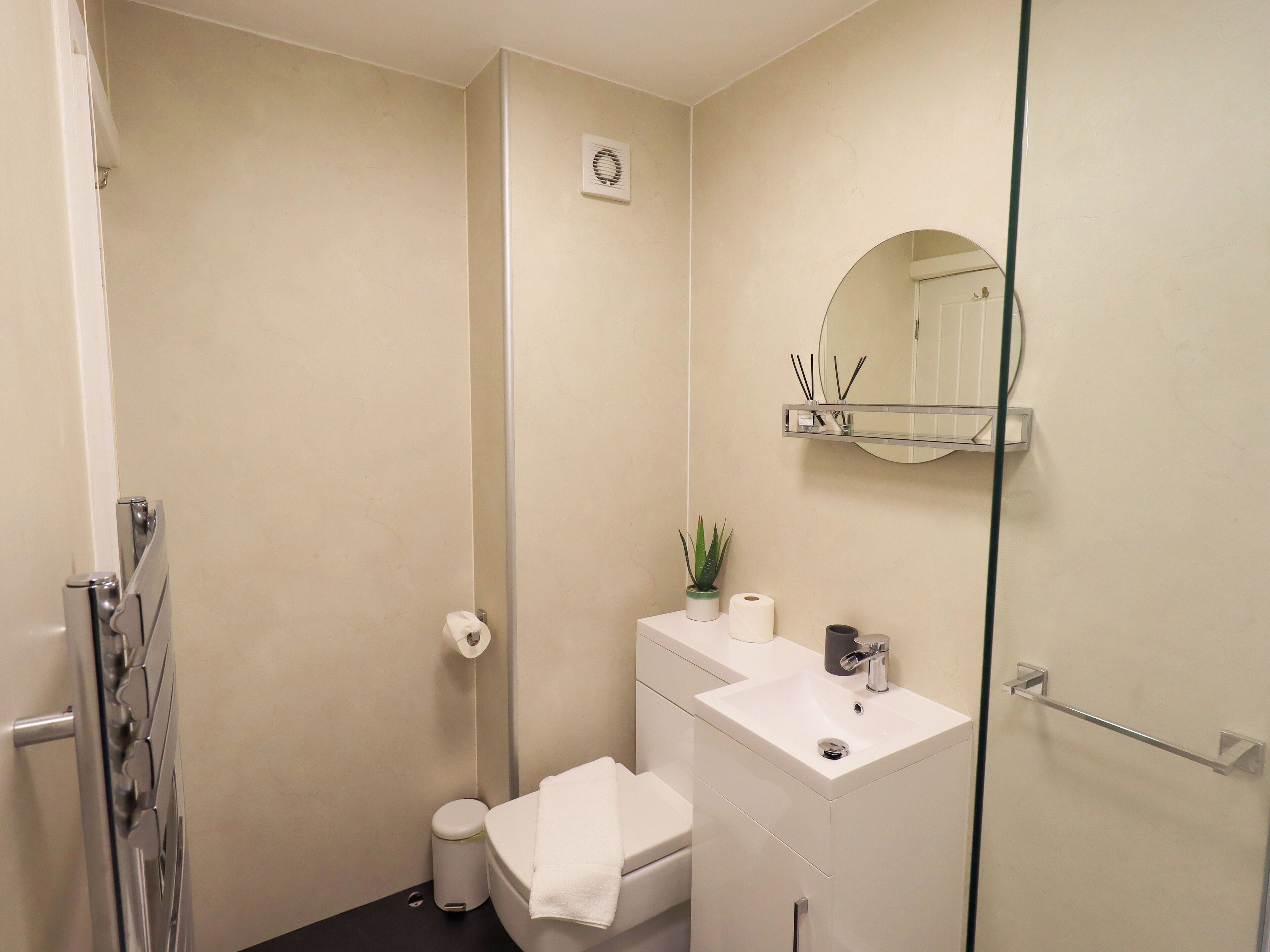 Een badkamer met toilet, wastafel en spiegel.