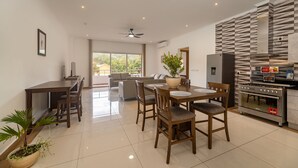 Une cuisine moderne dotée d’un four encastré et d’un coin repas avec une table et des chaises.