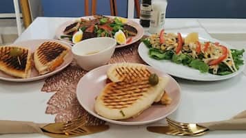 A table with plates of food, including grilled items and salads.