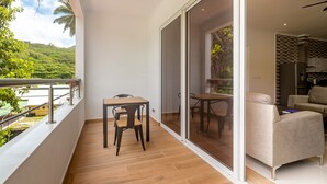 Un balcon avec un plancher en bois, une table et une chaise.