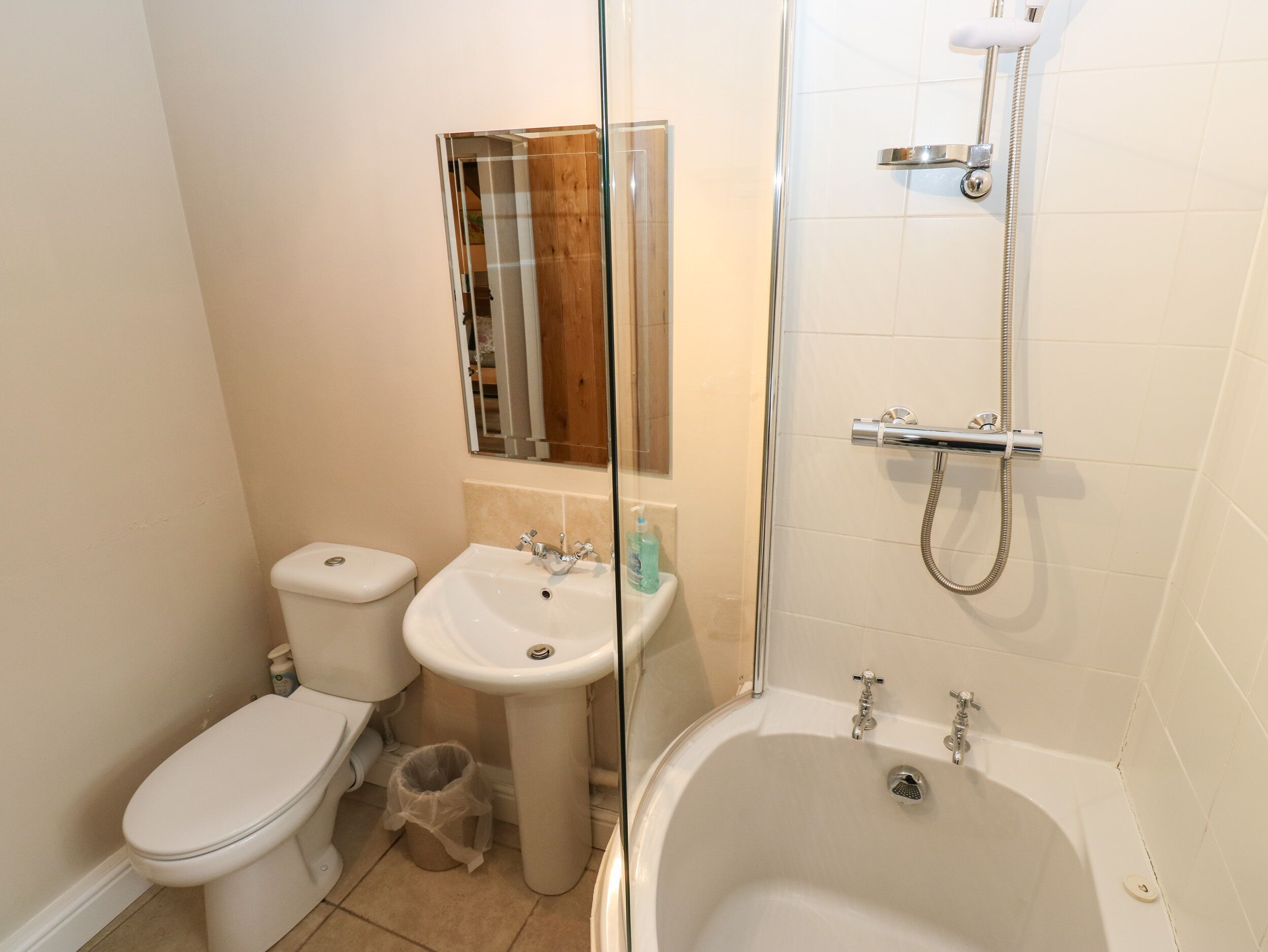 Een badkamer met toilet, wastafel en bad.
