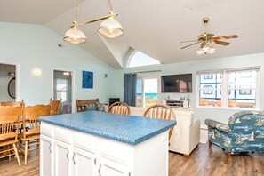 A spacious living area with a large island, a ceiling fan, and a view of the outside. - No Regrets - 4 BR home in the heart of Surf City!  Dog Friendly! (Surf City)