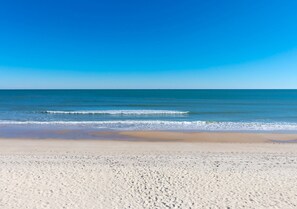 A beach with a clear sky and calm sea. - No Regrets - 4 BR home in the heart of Surf City! Dog Friendly! (Surf City)