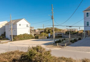 A coastal road with houses, a wooden staircase, and utility poles. - No Regrets - 4 BR home in the heart of Surf City! Dog Friendly! (Surf City)