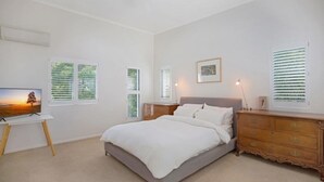 A bedroom with a bed, dresser, and a TV on a stand. - Ocean View Villa Marco (Marcus Beach)