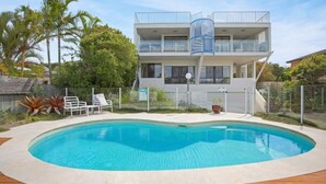 A two-story house with a swimming pool, a fenced backyard, and a balcony with a blue railing. - Ocean View Villa Marco (Marcus Beach)