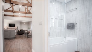 Une salle de bain moderne avec une grande baignoire blanche et une cabine de douche en verre.