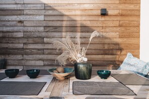 A wooden wall with a modern light fixture, a table with placemats, bowls, and a vase with dried plants. - 10 min walk from town center: large town house with small garden (Colmar)