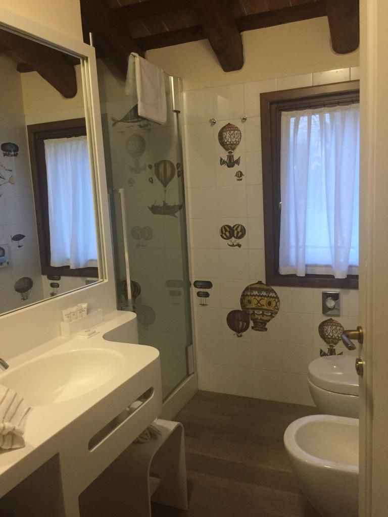 Un baño con cabina de ducha de vidrio, un lavabo blanco y un bidé.