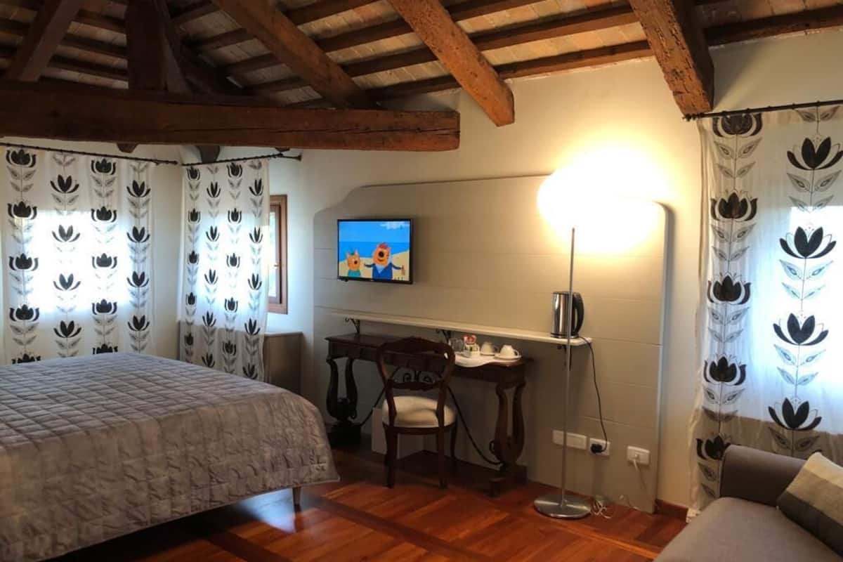 Una habitación con cama, escritorio, silla y sofá.