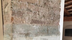 Une pièce avec un mur en briques et un tableau blanc sur lequel sont écrites des notes manuscrites.