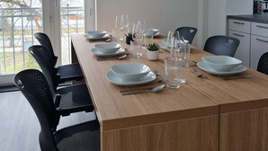 A modern dining area with a wooden table set for six, black chairs, and pendant lights. - Penthouse in Waterfront Villa Including Wifi Parking Balcony Netflix (Wildau)