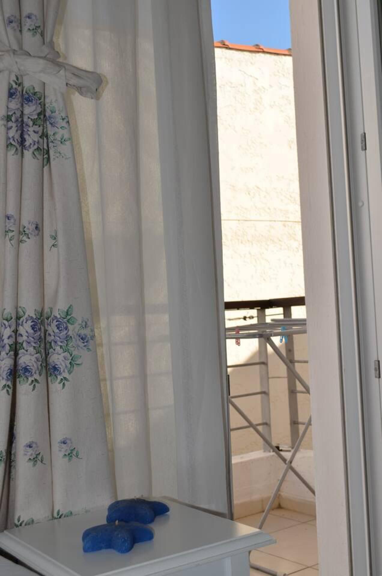 Una habitación con una puerta corrediza de vidrio que da a un balcón.