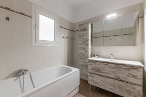 A modern bathroom with a freestanding bathtub, a large mirror, and a vanity with a rustic wood finish. - Superior 3BR Apartment in Chalandri (Chalandri)