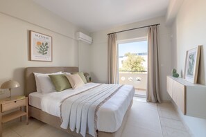 A bedroom with a bed, bedside table, and a window with curtains.