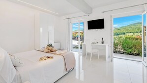 A modern bedroom with a bed, a desk, and a TV. - Amazing Villa Chimera White View Pool (Arezzo)