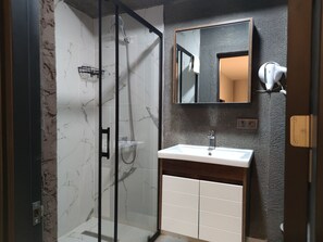 Habitación triple Deluxe, para no fumadores, vista a la ciudad | Baño | Regadera, secadora de cabello, pantuflas, toallas 