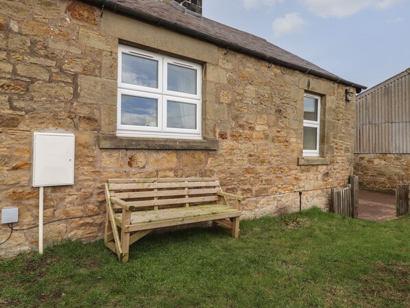 A stone building with a wooden bench outside. - Pond Cottage (Alnwick)