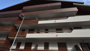 A multi-story building with a modern architectural design, featuring balconies and large windows. - Stefania by Interhome (Aprica)
