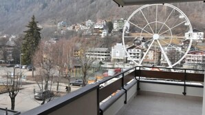 A balcony with a view of a town and a large Ferris wheel. - Stefania by Interhome (Aprica)