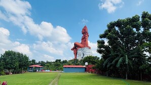 A large outdoor statue in a grassy area with a clear sky. - Shiv Ashray Resort (Nathdwara)