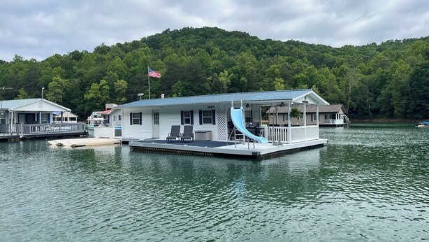 A floating house with a dock, a covered deck, and a small boat. - Floating Cabin - Another Day in Paradise at Whitman Hollow Marina (LaFollette)