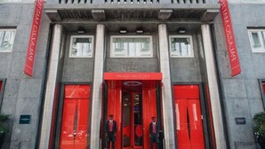 A building entrance with red doors and columns, and two uniformed guards standing outside. - Autograph Collection Palazzo Matteotti, The Dedica Anthology (Milan)