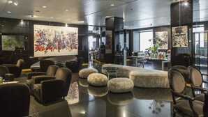 A modern lobby with a large abstract art piece, comfortable seating, and a glass coffee table. - Autograph Collection Palazzo Matteotti, The Dedica Anthology (Milan)