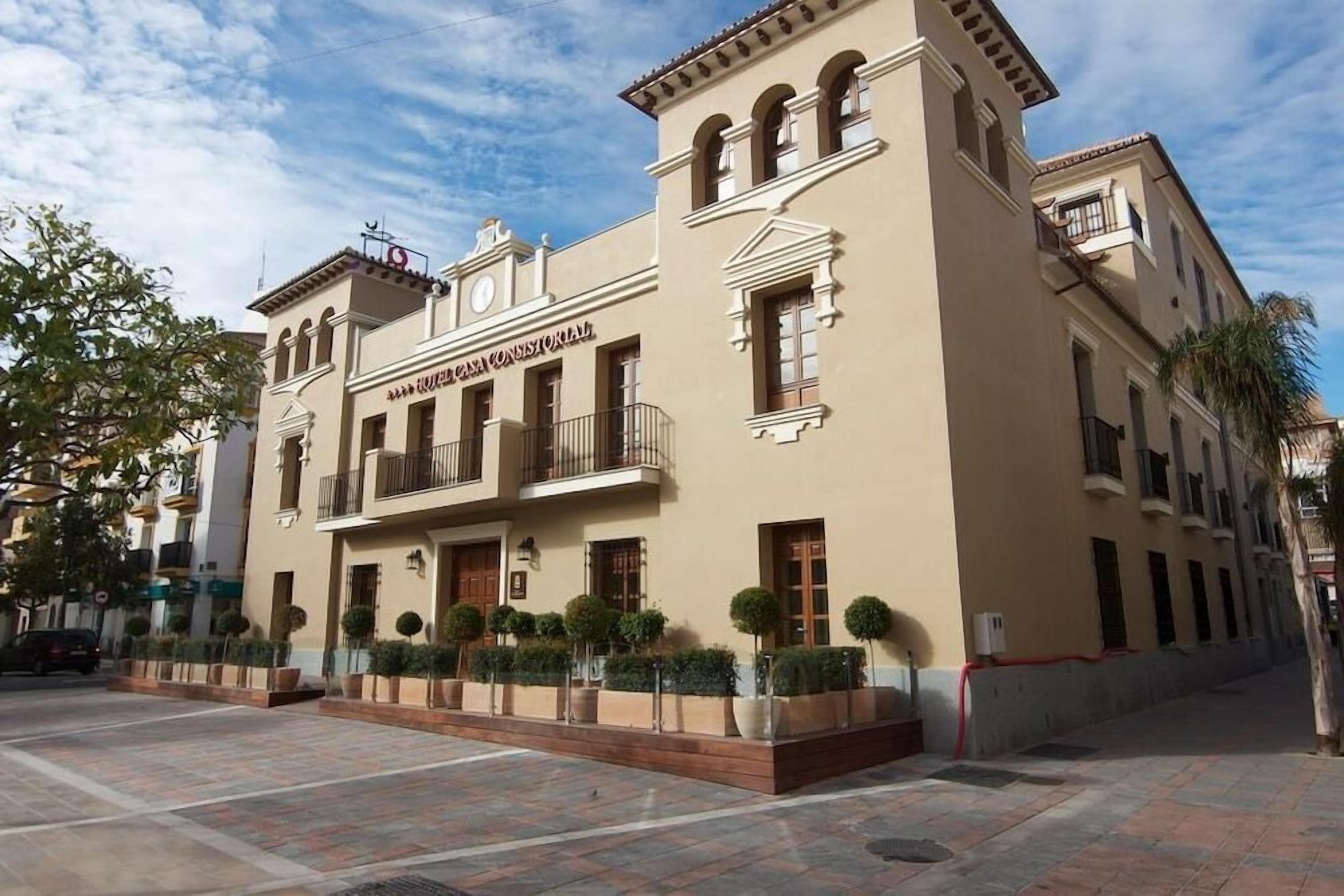 Un edificio de estilo arquitectónico clásico, con una entrada central que incluye un balcón, varias ventanas y un techo plano.