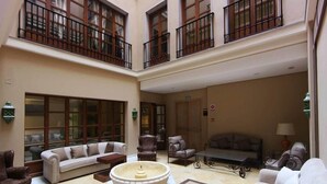 A spacious atrium with a high ceiling, multiple seating areas, and large windows. - Hotel Casa Consistorial (Fuengirola)