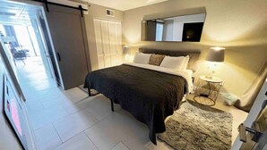 A bedroom with a bed, bedside table, lamp, and a view of the hallway. - Penthouse Suite/ Oceanfront/Prime location (Myrtle Beach)