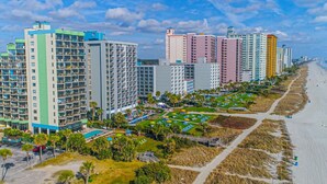 A beachfront hotel with multiple high-rise buildings, a sandy beach, and a well-maintained resort area with pathways and greenery. - Penthouse Suite/ Oceanfront/Prime location (Myrtle Beach)