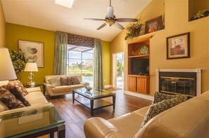 Cozy living room with a comfortable seating area, fireplace, and large window.