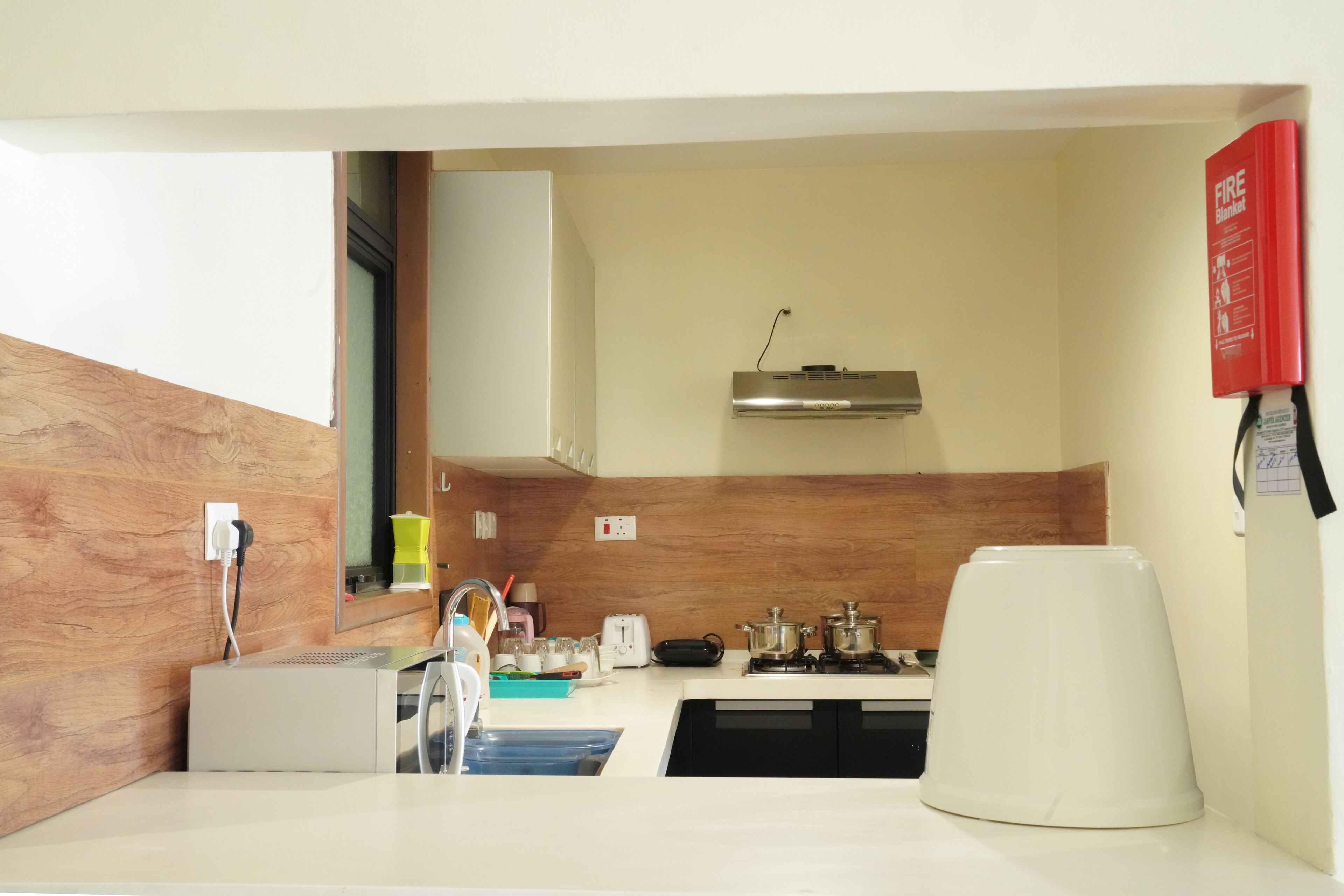 Una cocina moderna equipada con microondas, tostadora, hervidor y cafetera.