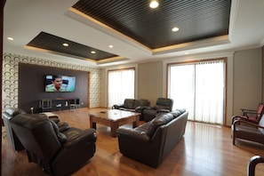 Three-Bedroom Apartment | Área de sala de estar | Smart TV de 55 pulgadas con canales por cable y televisión