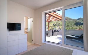 Relax in a serene mountain view room with an outdoor space and comfortable seating area.